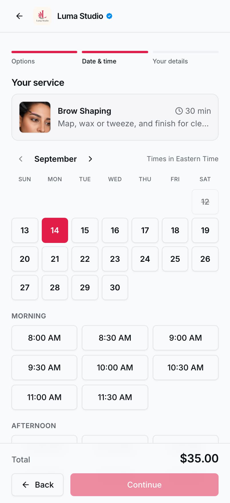 The booking wizard on a phone, showing a month of dates with one selected and the open morning and afternoon time slots beneath it